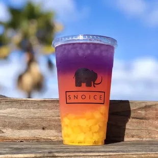 a purple and orange drink in a plastic cup