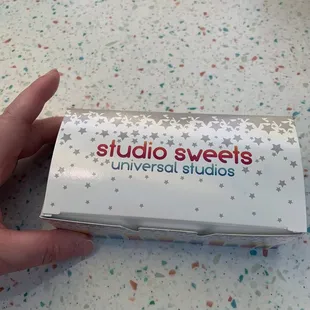 a hand holding a box of sweets