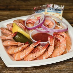 a plate of shrimp with a side of dipping sauce