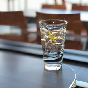 Glass of water with the AM Eatery logo on it.