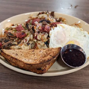 Corned beef hash with mushrooms, eggs over-medium, wheat toast, and jelly