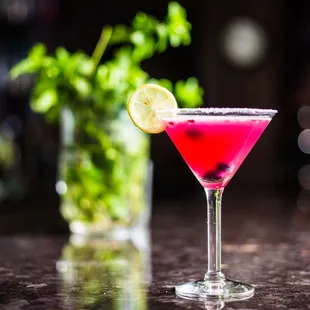 a pink cocktail with a lime slice