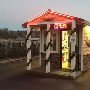 a small building with a neon sign