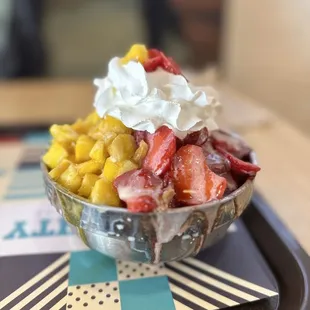 a bowl of strawberries, corn, and whipped cream