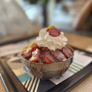 a bowl of strawberries and whipped cream