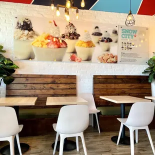 tables and chairs in front of a colorful mural
