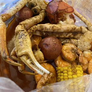 crab legs, corn, potatoes, corn on the cob
