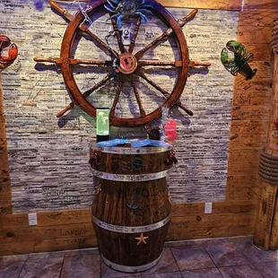 a ship wheel and a wooden barrel