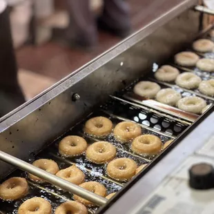 a conveyor belt filled with donuts