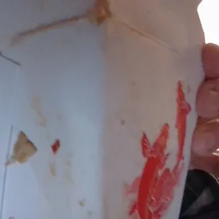 a hand holding a piece of pizza