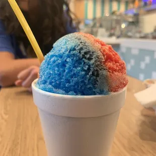 Mini shaved ice put in...a styrofoam cup. Be aware to check the middle of the shaved ice. Mine was plain ice with no syrup.