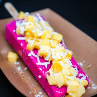 Pitaya pop with fresh mango topping and shredded coconut.