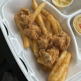 Chicken nuggets with fries and honey mustard.