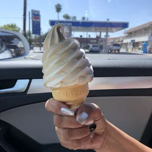 a hand holding an ice cream cone
