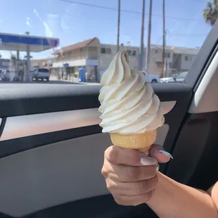 a person holding a cone of ice cream