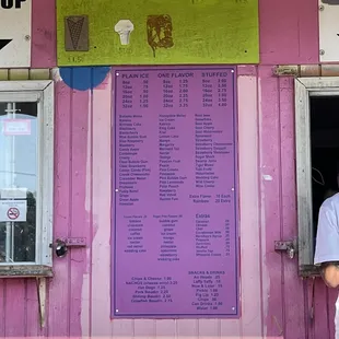 a man standing in front of a pink building