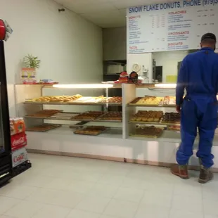 a man standing in front of a bakery counter
