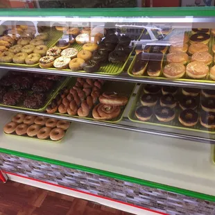 a variety of donuts in a display case