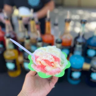 a hand holding a bowl of ice cream