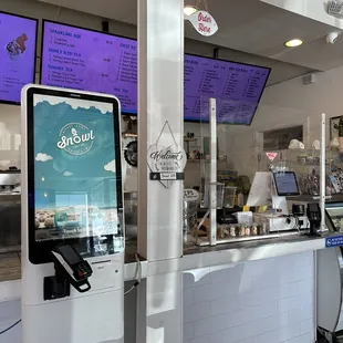 the counter of a restaurant with menus on the wall