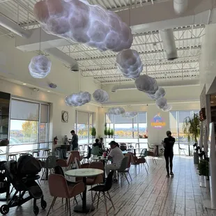 people sitting at tables with umbrellas hanging from the ceiling