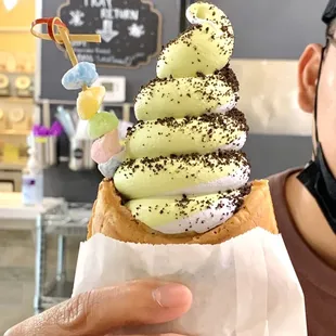 Matcha and taro swirled ice cream in a fish cone, filled with Nutella, topped with Oreo crumbles and mochi