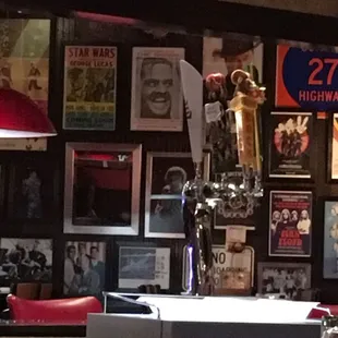 a bar with red chairs and posters on the wall
