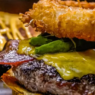 a burger with onion rings and bacon