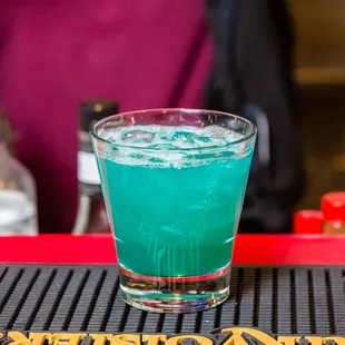 a blue drink in a glass