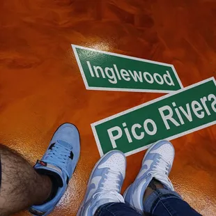 two people standing next to a pico river sign
