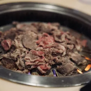 the meat being cooked in a skillet