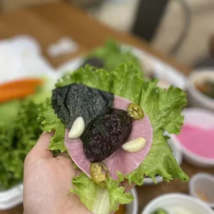 a hand holding a piece of lettuce