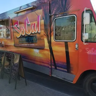 a colorful food truck parked on the side of the road
