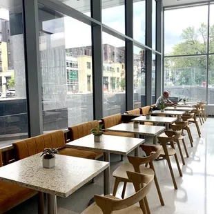 a row of tables and chairs in front of a large window