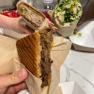 a person holding a sandwich in a wrapper