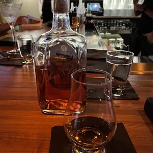 a glass of whiskey and a decanter