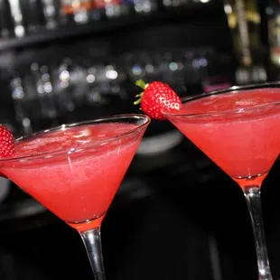 two cocktails with strawberries in them