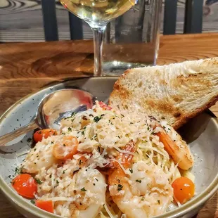 a bowl of pasta and a glass of wine