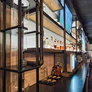 a view of a bar with shelves and televisions