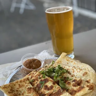 a plate of quesadillas and a glass of beer
