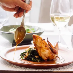 a plate of food being drizzled with a spoon