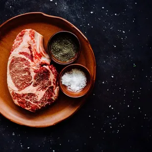 a steak on a plate with salt and pepper