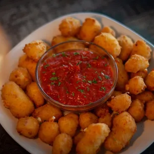 a plate of tater tots and a bowl of ketchup