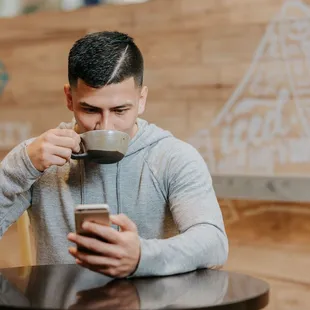a man drinking a cup of coffee