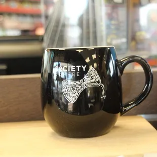 a black coffee mug with a picture of a dog on it