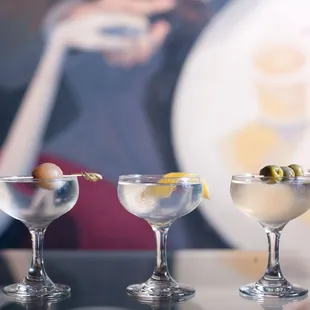 three martinis with olives in them