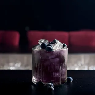 a blueberry cocktail in a glass with ice