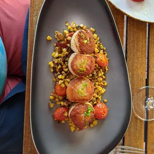 Scallops with charred corn and tomato.