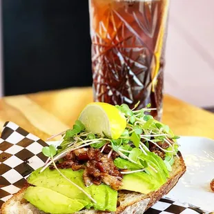 a sandwich with avocado and sprouts