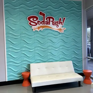 a couch in front of a soda rush sign
